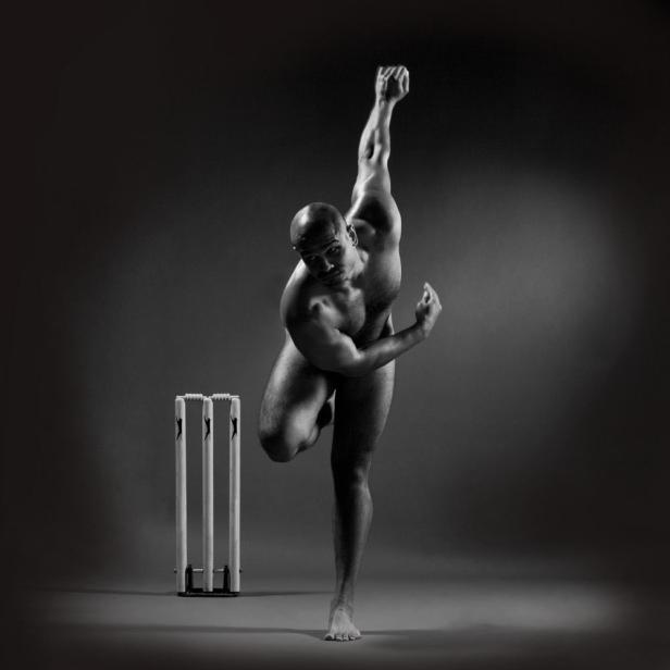 Ein muskulöser Mann in Wurfpose steht neben einem Cricket-Wicket.