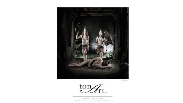 Zwei Frauen mit Hörnern und ein Mann mit einem Adler in einer dunklen Waldhütte.