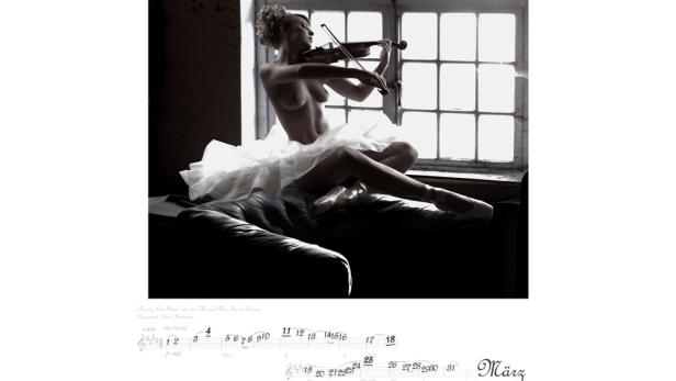 Eine Ballerina sitzt mit nacktem Oberkörper und spielt Geige.