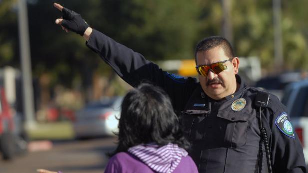 Ein Polizist in Brownsville, Texas, gibt einer Frau Anweisungen.