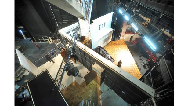 Blick von oben auf ein Filmset mit unfertigen Hausfassaden und Bühnentechnik.