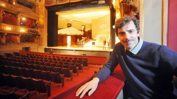 Ein Mann steht in einem Theater mit Blick auf die Bühne.