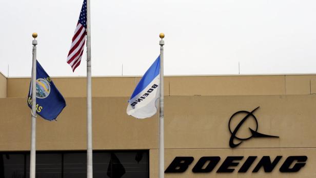 Das Boeing-Logo ist an einem Gebäude mit der amerikanischen Flagge und der Flagge von Kansas zu sehen.