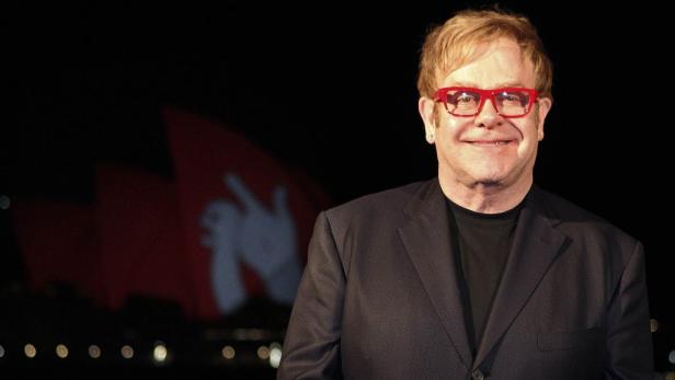 Elton John mit roter Brille vor dem Opernhaus von Sydney.