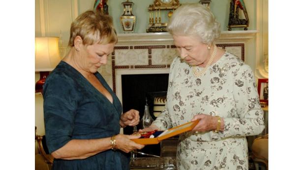 Königin Elisabeth II. überreicht Judi Dench eine Auszeichnung.