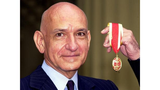 Ben Kingsley hält eine Auszeichnung in der Hand.