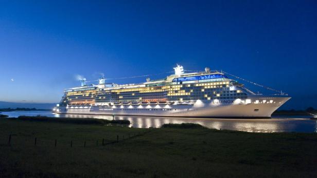 Die „Celebrity Equinox“ fährt nachts auf einem Fluss.