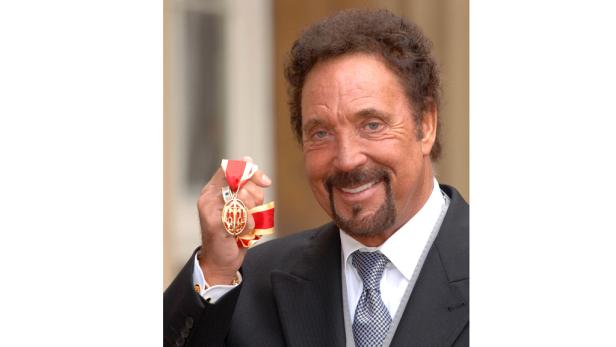 Tom Jones hält eine Auszeichnung in seiner Hand.