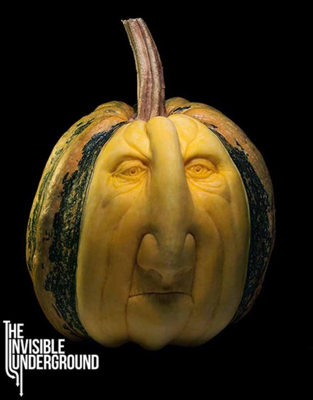Ein geschnitzter Kürbis mit einem menschlichen Gesichtsausdruck vor schwarzem Hintergrund.