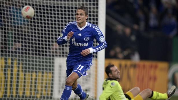 Ein Fußballspieler im blauen Trikot mit der Nummer 11 läuft auf das Tor zu.