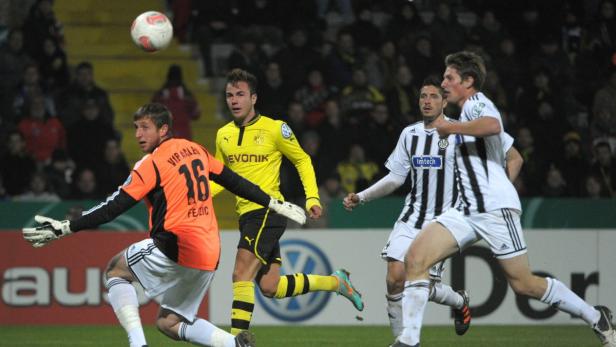 Ein Fußballspiel mit Spielern in gelben und schwarz-weiß gestreiften Trikots.