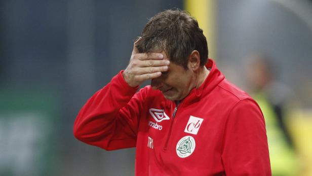 Ein enttäuschter Trainer hält sich die Hand vor das Gesicht.