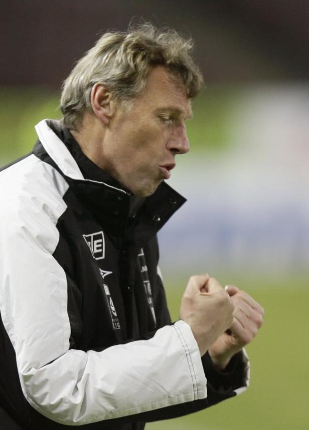 Ein Mann in einer schwarz-weißen Jacke ballt die Fäuste.