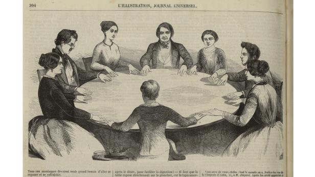 Eine Gruppe von Personen sitzt an einem runden Tisch.