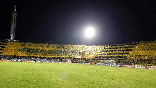 Ein Fußballstadion mit gelb-schwarzer Tribüne bei Nacht.