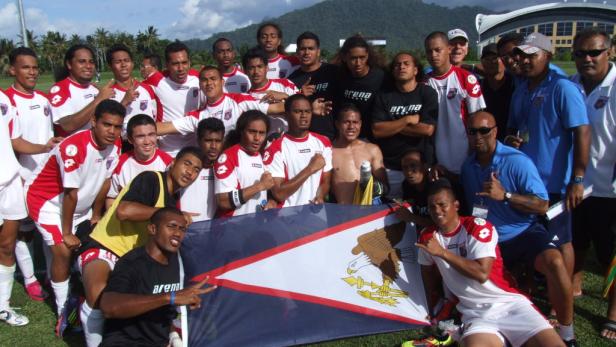 Das Fußballteam von Amerikanisch-Samoa posiert mit der Flagge des Landes.
