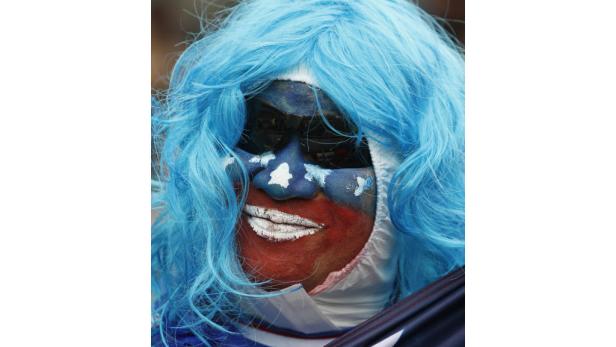 Ein Fan mit blau gefärbten Haaren und Gesichtsbemalung in den Farben der US-Flagge.