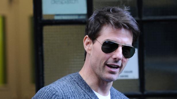 Tom Cruise trägt eine Sonnenbrille und einen grauen Pullover.