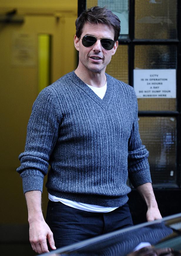 Tom Cruise trägt eine Sonnenbrille und einen grauen Pullover.