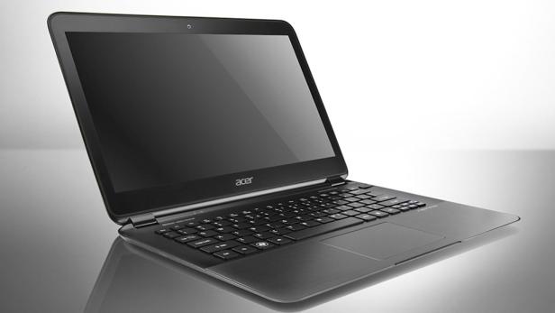 Ein geöffneter Acer Laptop steht auf einer glänzenden Oberfläche.