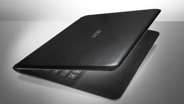 Ein teilweise geöffneter, schwarzer Acer Laptop auf einem Tisch.