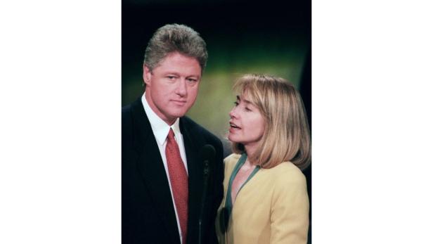 Bill und Hillary Clinton stehen zusammen vor einem Mikrofon.