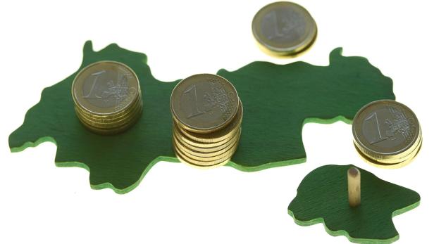 Euro-Münzen liegen auf einer grünen Karte.