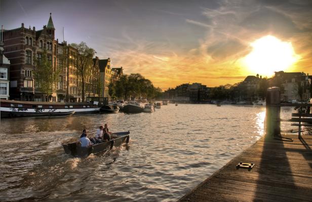 Eine Bootsfahrt auf einem Kanal in Amsterdam bei Sonnenuntergang.