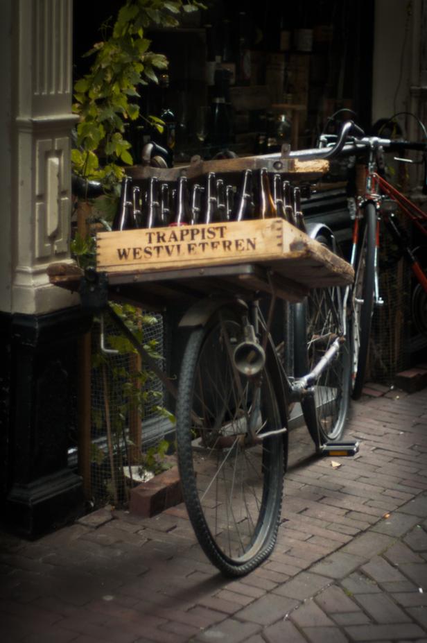 Ein Fahrrad transportiert eine Kiste mit Trappist Westvleteren Bierflaschen.