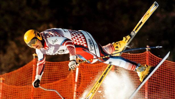 Ein Skirennfahrer springt während eines Wettkampfs über eine Piste.