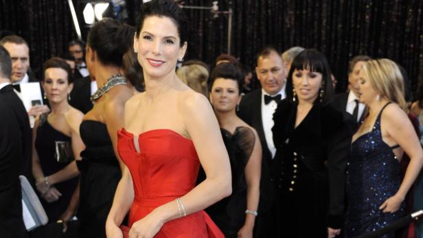 Sandra Bullock in einem roten Kleid auf dem roten Teppich.