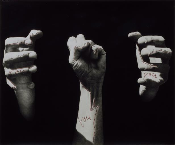 Drei Hände vor schwarzem Hintergrund, beschriftet mit dem Wort „You“ und roten Linien.