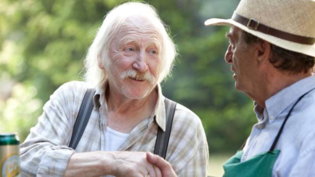 Zwei ältere Männer unterhalten sich im Freien.