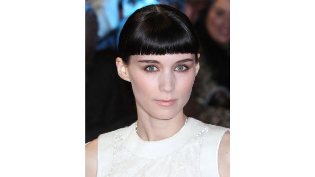 Ein Porträt von Rooney Mara mit dunklen Haaren und hellem Kleid.