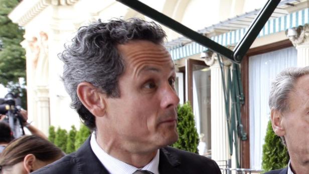 Ein Mann mit grauem, gewelltem Haar schaut zur Seite.