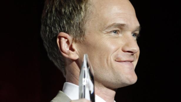 Neil Patrick Harris lächelt und hält eine Auszeichnung.