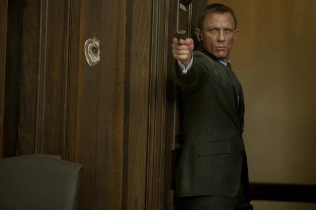 Daniel Craig als James Bond zielt mit einer Pistole auf etwas außerhalb des Bildes.