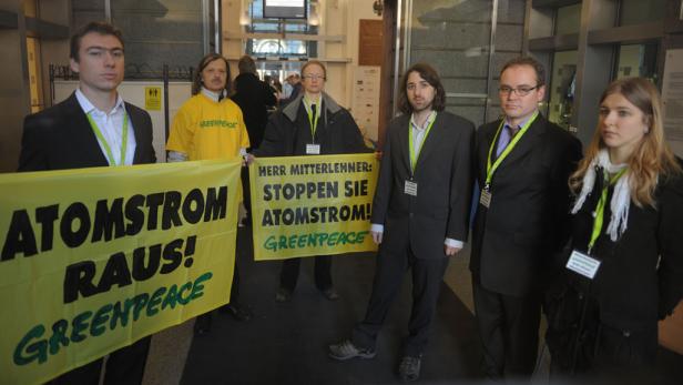 Eine Gruppe von Greenpeace-Aktivisten demonstriert mit gelben Bannern gegen Atomstrom.