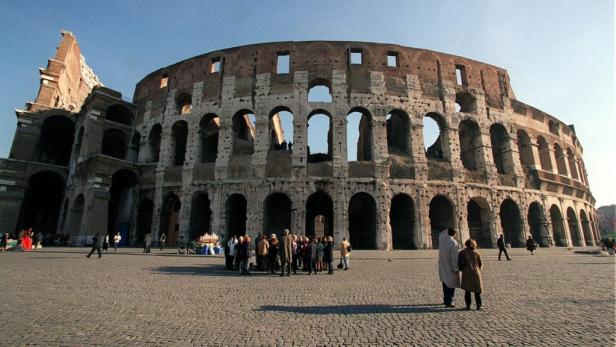 Das Kolosseum in Rom mit einer Gruppe von Touristen davor.