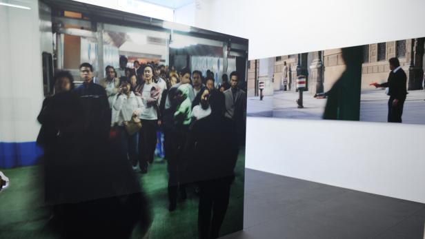 In einer Kunstgalerie hängen großformatige Fotografien an der Wand.