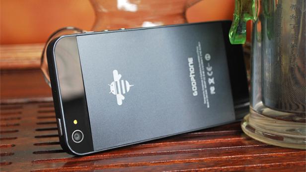 Ein schwarzes Goophone-Smartphone liegt auf einer hölzernen Oberfläche.