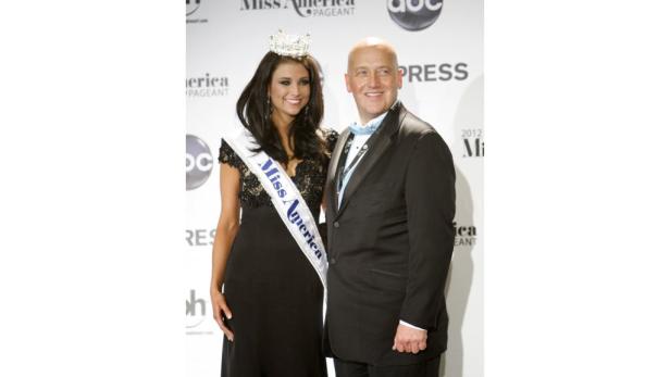 Eine ehemalige Miss America posiert mit einem Mann im Anzug.