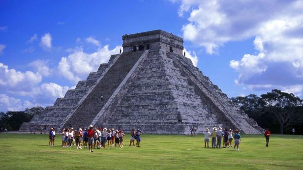 Die Pyramide des Kukulcán in Chichén Itzá, Mexiko, mit einer Gruppe Touristen im Vordergrund.
