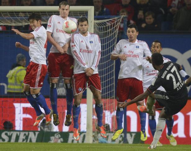 Fußballspieler des Hamburger SV springen bei einem Spiel in die Luft.