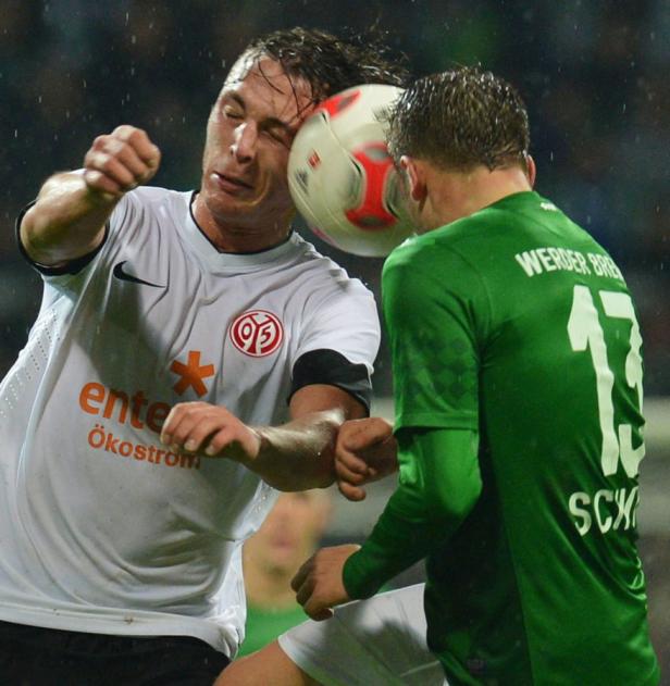 Ein Fußballspieler wird von einem Ball am Kopf getroffen.