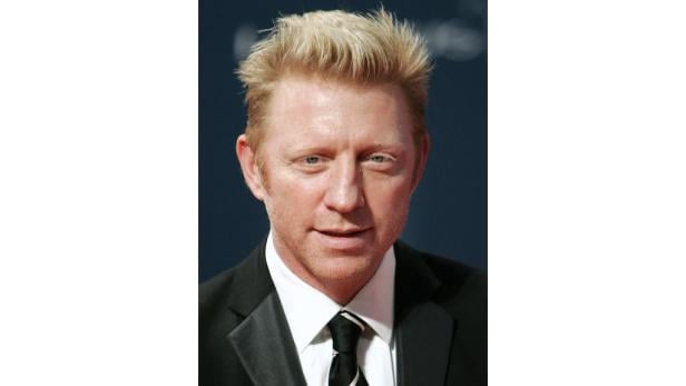 Ein Porträt von Boris Becker mit blonden Haaren und einem schwarzen Anzug.