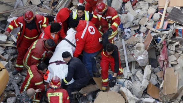 Rettungskräfte bergen eine Person aus den Trümmern eines zerstörten Gebäudes.