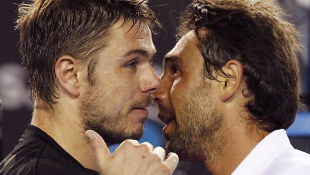 Zwei verschwitzte Tennisspieler stehen sich Stirn an Stirn gegenüber.