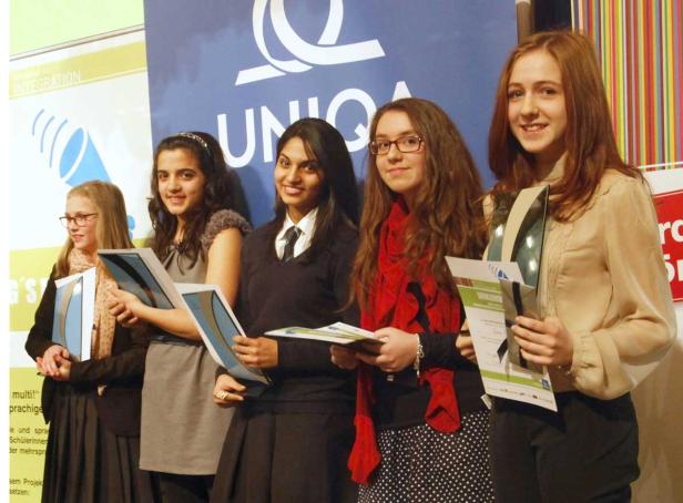 Fünf junge Frauen halten Urkunden vor einem UNIQA-Banner in die Kamera.