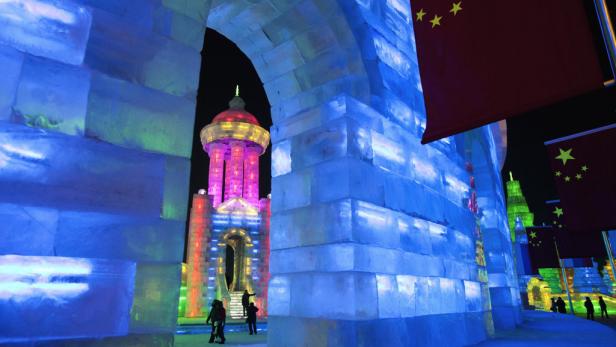 Eisskulpturen und chinesische Flaggen beim Harbin International Ice and Snow Sculpture Festival.